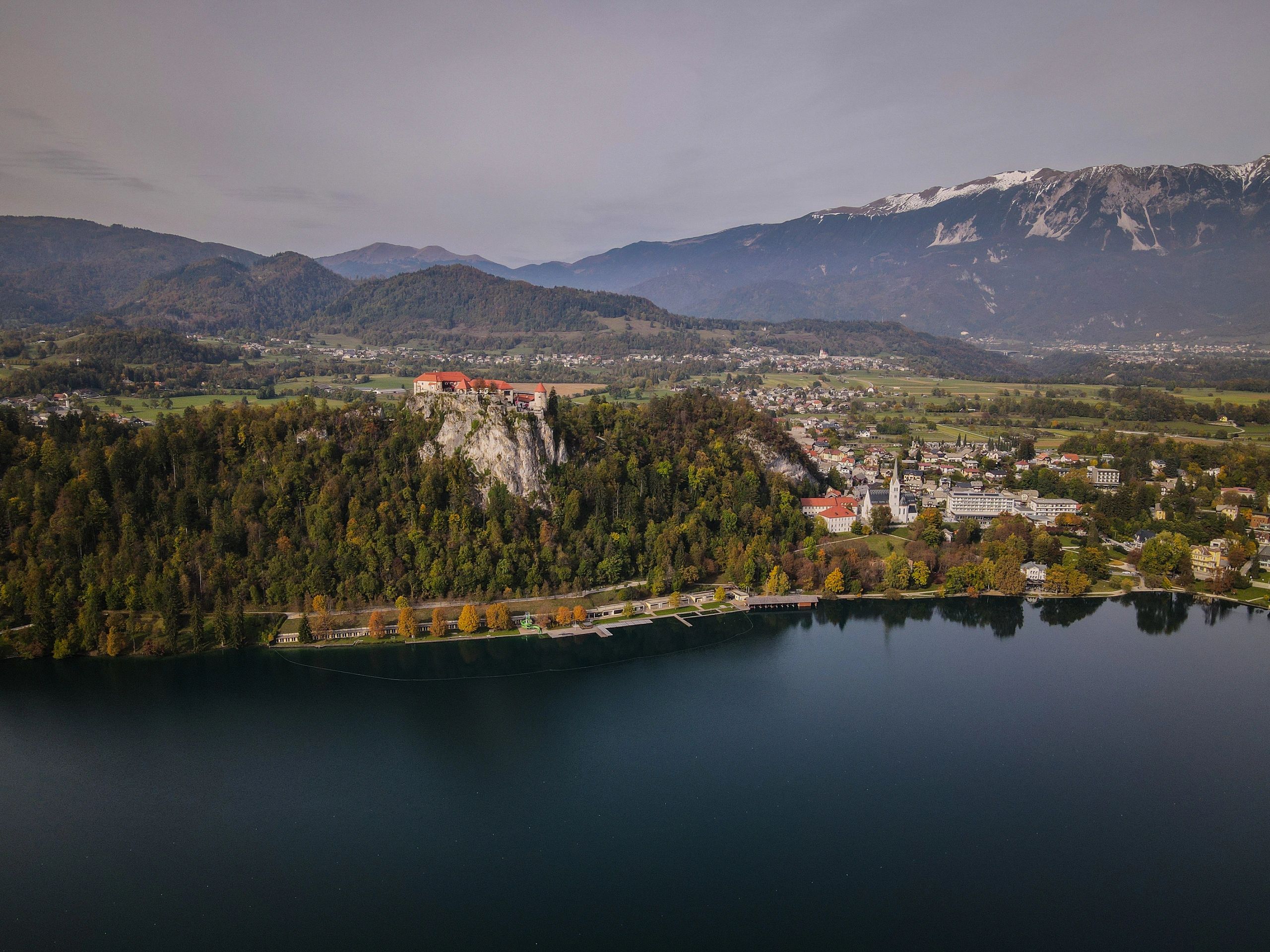 Aerial View of Bled Castle, Lake Bled, and Snow-Capped Julian Alps in Autumn